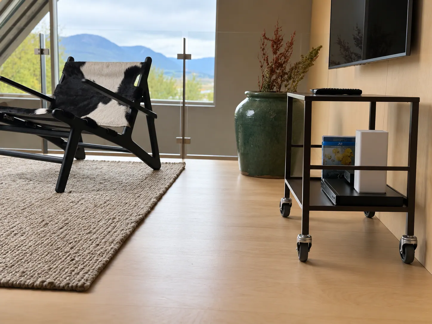 Apartment 15B: Living room with a lounge chair, TV and bar cart
