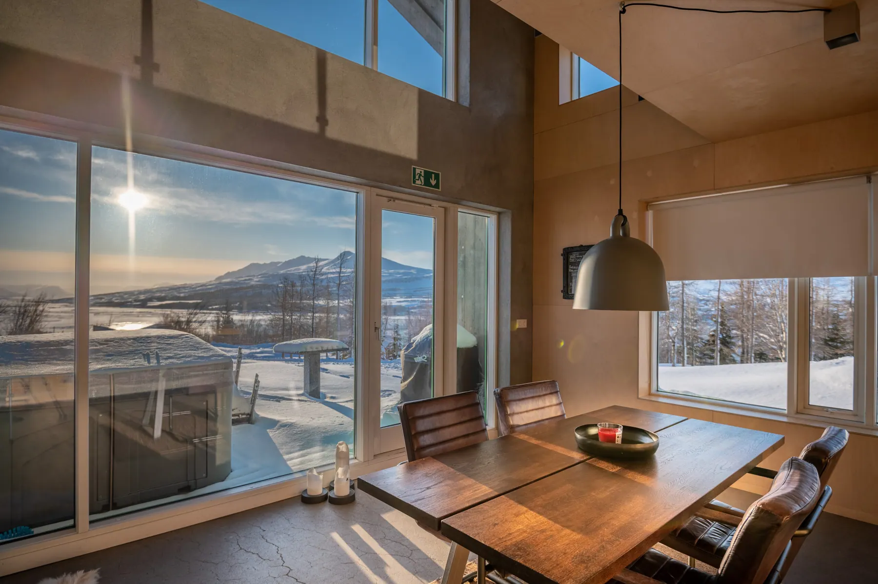 Apartment 15A: Dining table by tall windows with a fjord view