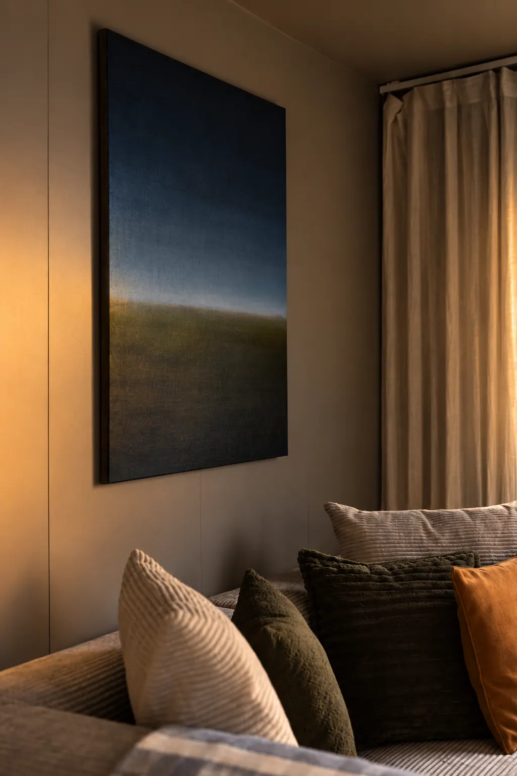The Cottage: Sofa with cushions under a large painting